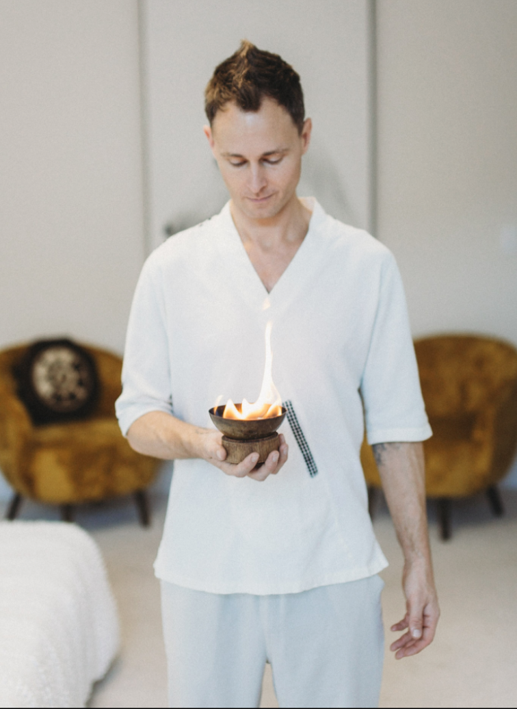 Jonathan MacCaul holding a bowl with a flame